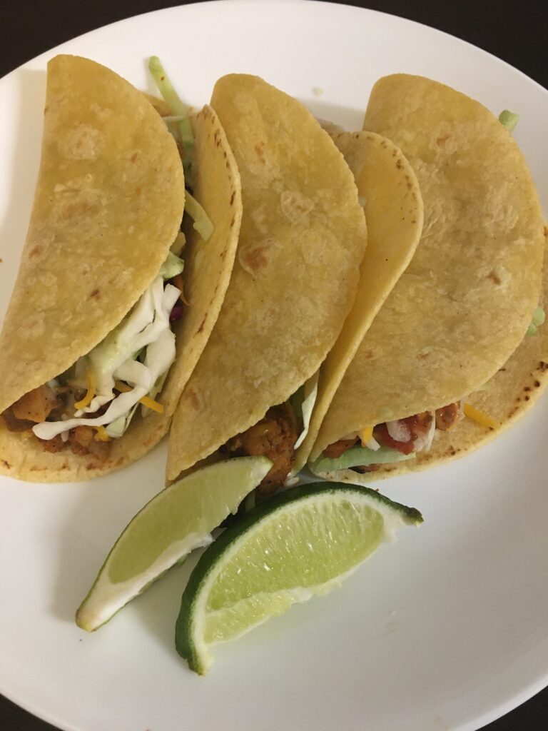 prepared tacos on a plate with limes